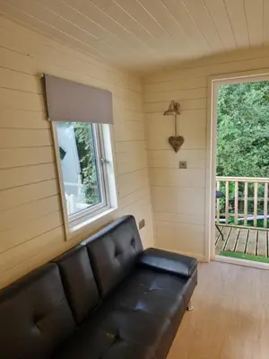 a living room with a couch and a window at Glamping Hut - Sleeps 2 hot tub & parking in Welshpool