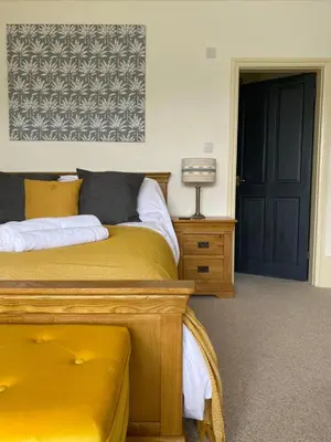 a bedroom with a yellow bed and a black door at No6 in Barmouth