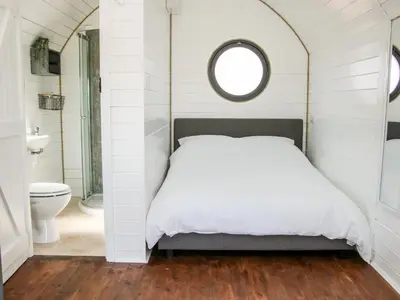 a bedroom with a bed and a bathroom with a toilet at Withy Willows in Craven Arms