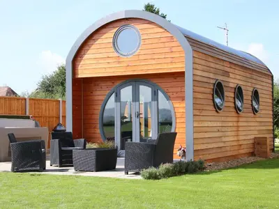 a wooden shed with chairs in a yard at Cherry Blossom in Craven Arms