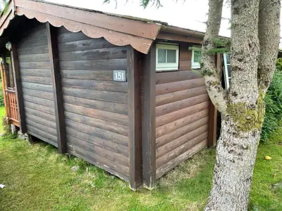 a large wooden garage with a tree next to it at Cosy 2 bedroom Log Cabin in Snowdonia Cabin151 in Trawsfynydd