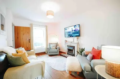a living room with a couch and a fireplace at 13 Tabernacle Street - Aberaeron in Aberaeron