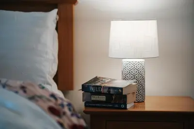 a stack of books sitting on a table next to a lamp at 13 Tabernacle Street - Aberaeron in Aberaeron