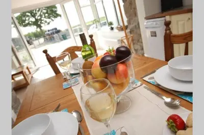 a table with a bowl of fruit and a glass of wine at 2 Bed Rural cottage between the mountains and Sea in West Wales in Lampeter