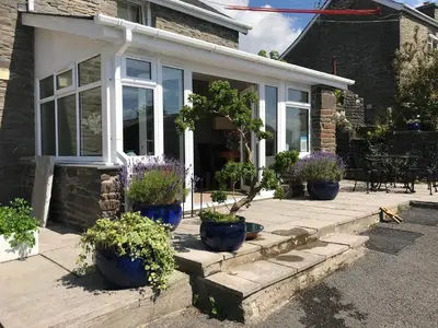 a house with blue pots of flowers in front of it at 2 Bed Rural cottage between the mountains and Sea in West Wales in Lampeter