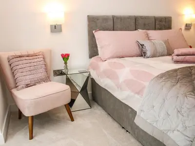 a bedroom with a bed and a chair and a glass table at 42 Albury Place in Shrewsbury