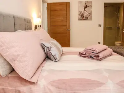 a bed with pink sheets and pillows on it at 42 Albury Place in Shrewsbury