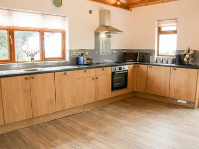 a large kitchen with wooden cabinets and a sink at Toot View in Ludlow