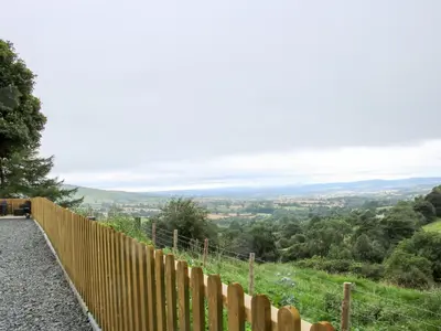 a fence on top of a hill with a view at Toot View in Ludlow