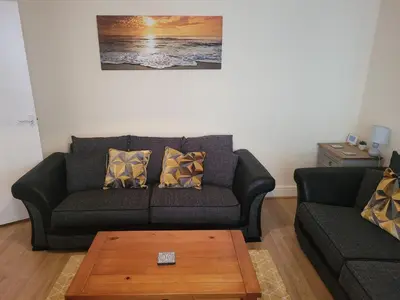 a living room with a couch and a coffee table at Large 5 bed town-centre home close to the beach, sleeps 9 in Aberystwyth