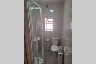 a bathroom with a toilet and a sink and a shower at Large 5 bed town-centre home close to the beach, sleeps 9 in Aberystwyth