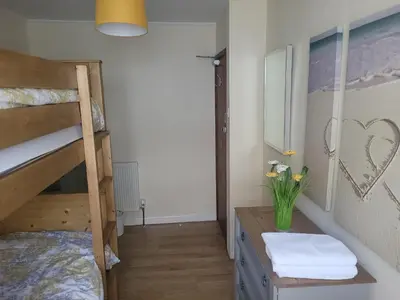 a bedroom with a bunk bed and a desk with towels at Large 5 bed town-centre home close to the beach, sleeps 9 in Aberystwyth
