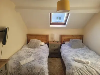 a bedroom with two beds and a window at Large 5 bed town-centre home close to the beach, sleeps 9 in Aberystwyth