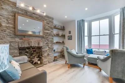 a living room with a stone fireplace and chairs at 1 Bed in Aberystwyth oc-bow285 in Aberystwyth