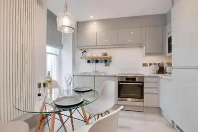 a kitchen with a glass table and white cabinets at 1 Bed in Aberystwyth oc-bow285 in Aberystwyth