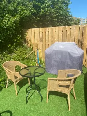 a patio with two chairs and a table and a fence at The Pod in Aberystwyth