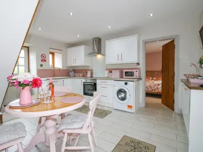 a kitchen with a table and chairs and a microwave at Meadow Barn in Craven Arms