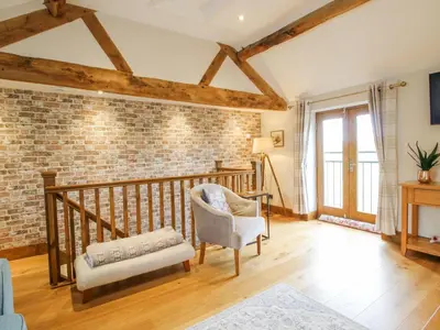 a living room with a brick wall at Meadow Barn in Craven Arms