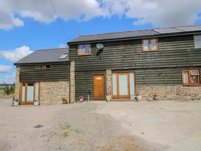 a large wooden house with two doors on it at Meadow Barn in Craven Arms