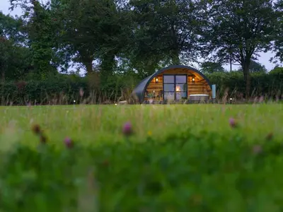 a small cabin in the middle of a field at The Piglet Pod in Llanarth