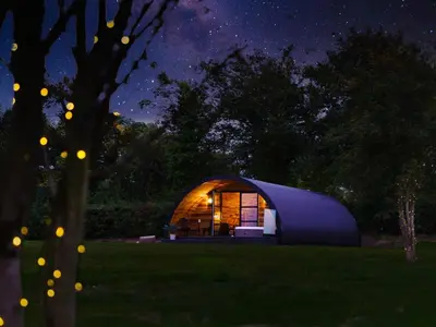a blue dome tent in a field at night at The Piglet Pod in Llanarth