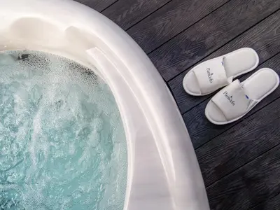 a pair of slippers next to a tub of water at The Piglet Pod in Llanarth