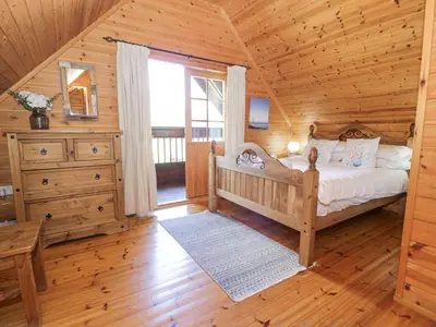 a bedroom with a bed in a log cabin at Sun View Lodge in Llanbedr