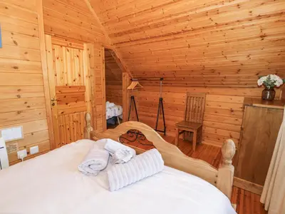 a bedroom with a bed in a log cabin at Sun View Lodge in Llanbedr
