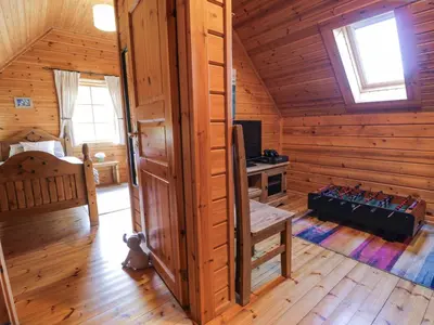 a large room with a wooden cabin with a tv at Sun View Lodge in Llanbedr