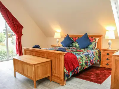 a bedroom with a large wooden bed with blue pillows at Holly Lodge in Welshpool