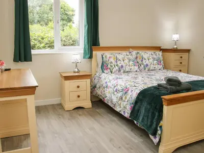 a bedroom with a bed and two night stands at Holly Lodge in Welshpool