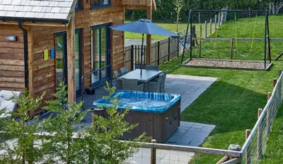 a hot tub in a yard with an umbrella at Holly Lodge in Welshpool