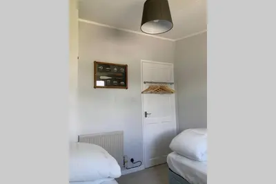 a room with two beds and a white door at Modern Funky Private Chalet at the Beach in Tywyn