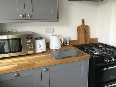 a kitchen with a stove top oven next to a microwave at bwthyn y porthmyn in Llandovery