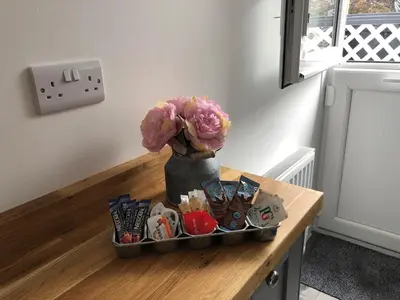 a table with a vase with flowers on it at bwthyn y porthmyn in Llandovery