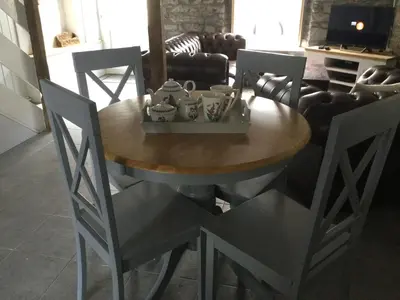 a dining room table with chairs and a table with teaisers on it at bwthyn y porthmyn in Llandovery