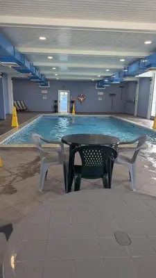 a pool with a table and two chairs in front of it at Gloria Stay - Aberystwyth Caravan in Aberystwyth
