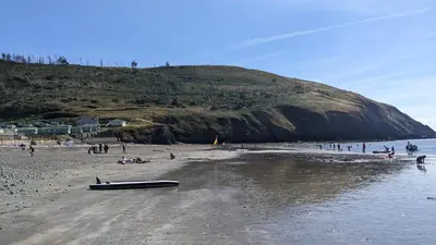 a beach with a boat laying on the sand at Gloria Stay - Aberystwyth Caravan in Aberystwyth
