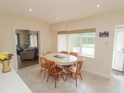 a kitchen and dining room with a table and chairs at Awel Y Berwyn in Oswestry