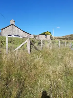 an old house in a field with a fence at Penystryd in Trawsfynydd