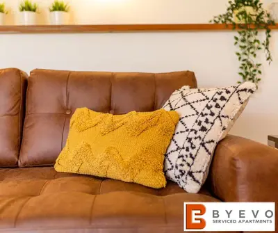 a brown couch with two pillows on it at ByEvo Oswestry Barn - Quirky romantic retreat or Cosy contractor base in Oswestry