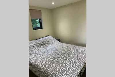 a bedroom with a bed and a window at Secluded Log Cabin in beautiful private gardens in Broxwood