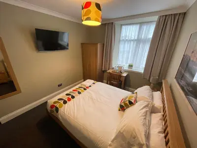 a bedroom with a bed with a white comforter at Y Griffin in Penrhyndeudreath