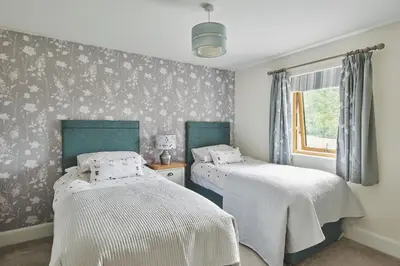 a bedroom with two beds and a window at Shepherds Rest in Llandyssil
