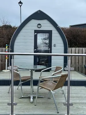 a table and chairs on a deck with a igloo at The Midi Pod in Aberystwyth