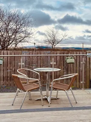 a patio with a table and two chairs and a fence at The Midi Pod in Aberystwyth