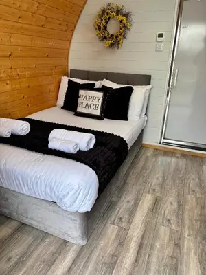 a bedroom with a bed with a happy harvest pillow at The Midi Pod in Aberystwyth