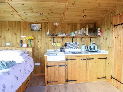 a kitchen with wooden walls and a sink in a room at Claerwen in Llandrindod Wells