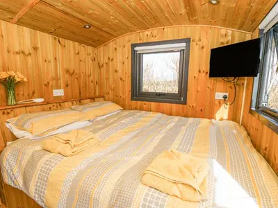 a bedroom with a bed in a wooden cabin at Elan in Llandrindod Wells