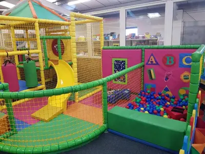 an indoor play room with a play gym with balls at D19 in Aberystwyth